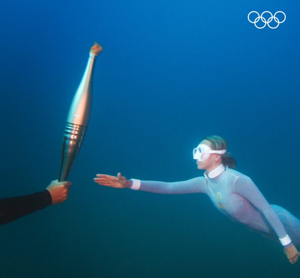 Passing the Olympic flame - under water